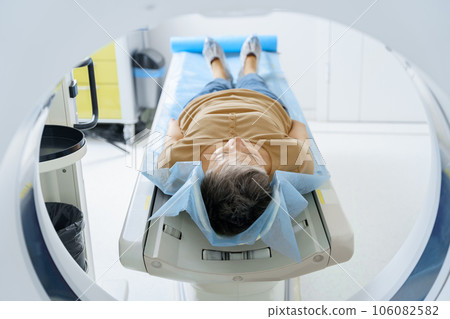 Female patient lying on table and entering CT machine during examination procedure in hospital Female patient lying on table and entering CT machine during examination procedure in hospital 106082582