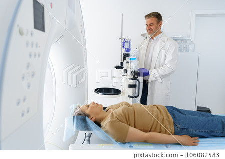 Doctor and female patient in the room of computed tomography at hospital. Healthcare concept Doctor and female patient in the room of computed tomography at hospital. Healthcare concept 106082583