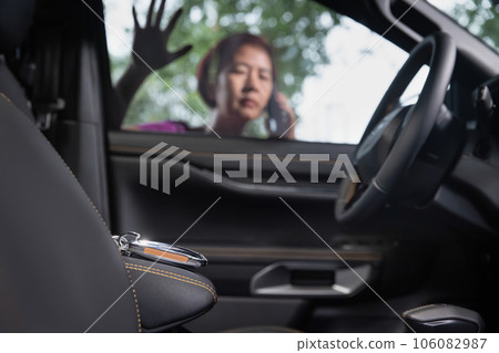 Senior asian woman forgot her key inside locked car. Senior asian woman forgot her key inside locked car. 106082987