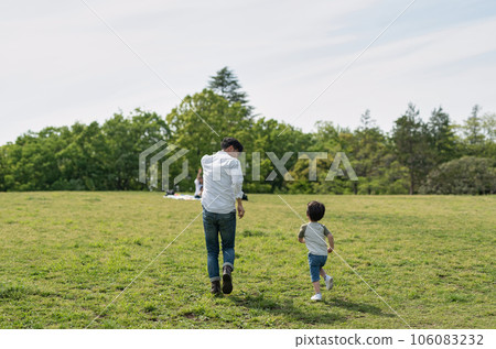 Back view of father and boy running together 106083232