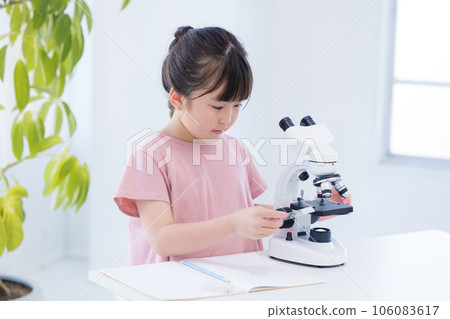 Elementary school girl studying with a microscope 106083617