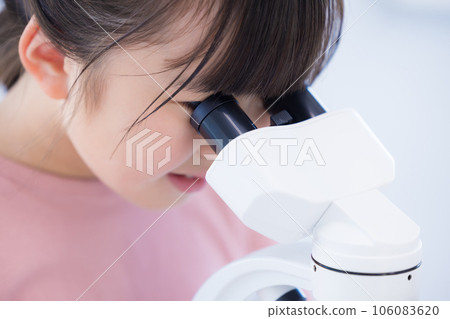 Elementary school girl studying with a microscope 106083620