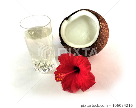 Coconut water in glass cup with cracked coconut and red hibiscus Coconut water in glass cup with cracked coconut and red hibiscus 106084216