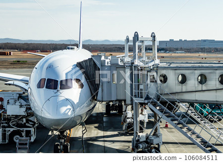 Scenery of airplanes waiting on the tarmac and the boarding bridge 106084511