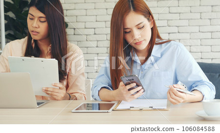Happy success business woman partner working together in company office corporate executive teamwork. Meeting Executive Asian business woman using laptop office desk with fist arm raised win happiness 106084588