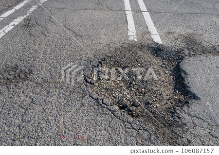 Parking where the asphalt surface has collapsed 106087157