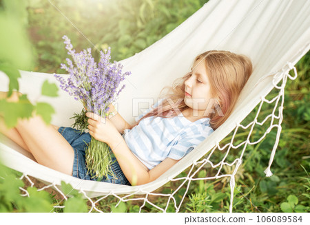 A little girl rests in a hammock  in the summer. 106089584