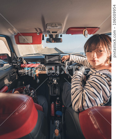 The woman in the driver's seat is looking back to back up 106089954