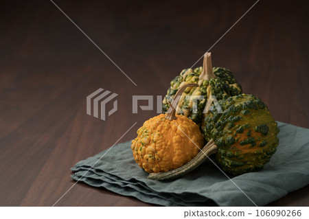 decorative pumpkins on a napkin on a walnut wood table decorative pumpkins on a napkin on a walnut wood table 106090266