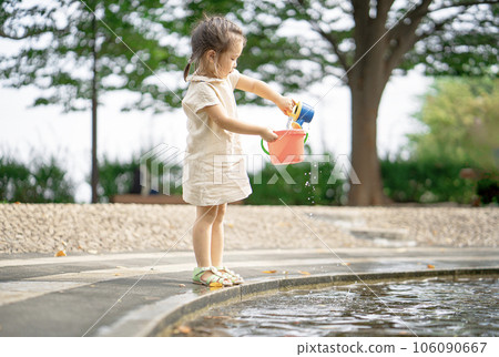 一個女孩在賈布賈布池塘的桶裡玩水 106090667