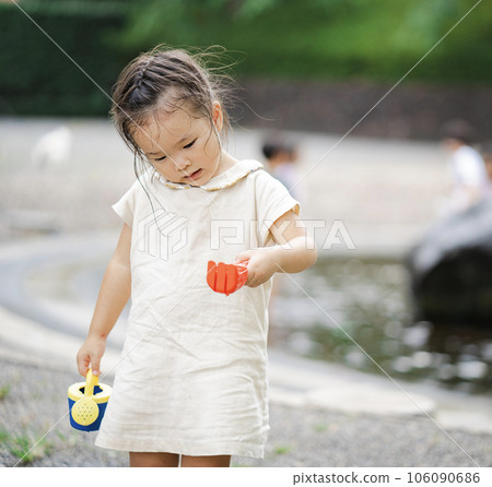 A girl playing with a toy in a squishy pond 106090686
