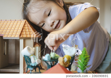 girl playing with a little doll girl playing with a little doll 106090691