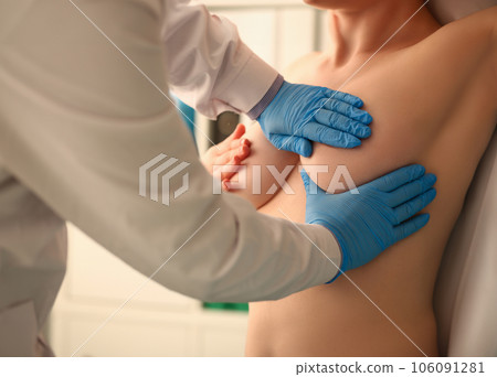 Hospital worker in uniform examining breasts of patient 106091281