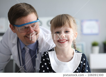 Smiling male doctor looking healthy happy child 106091300