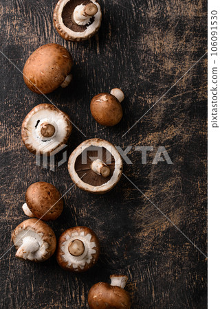 Raw champignon mushrooms on black background Raw champignon mushrooms on black background 106091530