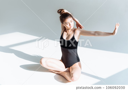 Morning exercise, yoga and stretching. Beautiful Asian girl practicing stretching in bright studio. Morning exercise, yoga and stretching. Beautiful Asian girl practicing stretching in bright studio. 106092030
