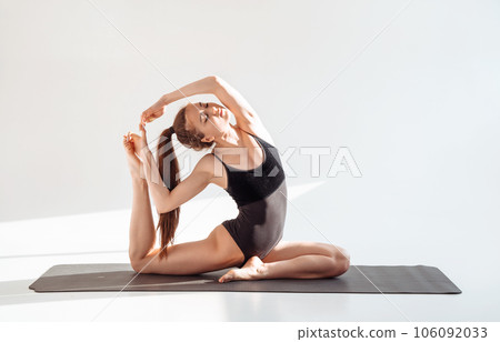 Advanced girl yogi practicing yoga in bright studio. 106092033