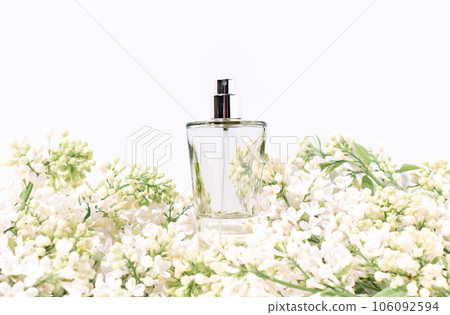Floral fragrance in perfumery concept made with perfume bottle in flowering branch of white lilac. Floral fragrance in perfumery concept made with perfume bottle in flowering branch of white lilac. 106092594