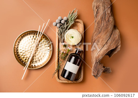 Tray with scented home perfume in glass jar with rattan sticks. Luxury aroma oil home fragrance with woody and flowers notes concept. Tray with scented home perfume in glass jar with rattan sticks. Luxury aroma oil home fragrance with woody and flowers notes concept. 106092617