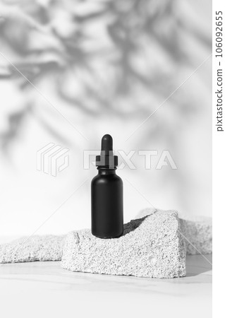 Empty black tube mockup on pumice stones for cosmetics product presentation. Minimal composition. Vertical studio photography. 106092655