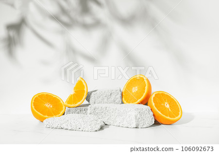 Beauty skin care product presentation podium and display made with porous stones and oranges on white sunny background. Studio photography. Beauty skin care product presentation podium and display made with porous stones and oranges on white sunny background. Studio photography. 106092673