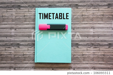The word TIMETABLE is written on a green notepad and on a wooden background. 106093311