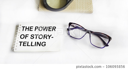 THE POWER OF STORY text written on a notepad with glasses, a magnifying glass and a notepad. 106093856