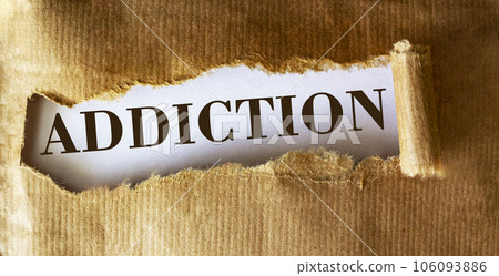 The word Addiction is written underneath brown torn paper. The word Addiction is written underneath brown torn paper. 106093886