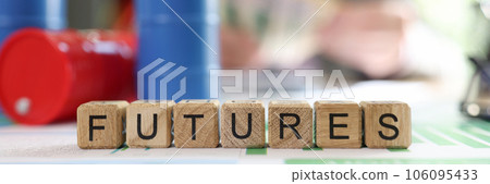 Word futures collected from wooden cubes with oil barrels and blurred business person in background. 106095433
