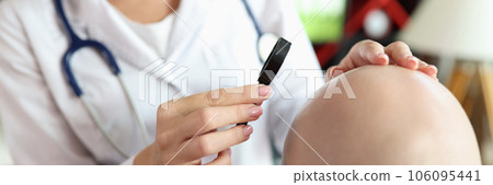 Female doctor looks at skin of bald patient through magnifying glass. Female doctor looks at skin of bald patient through magnifying glass. 106095441