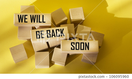 We will be back soon, text on wooden blocks and yellow background 106095960