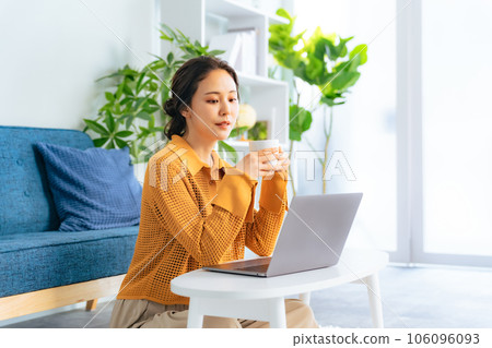 一個女人在客廳裡看電腦 106096093