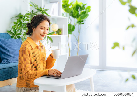 一位女士在客廳使用電腦 106096094