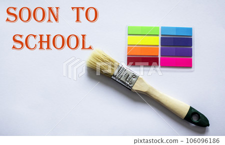 Written on the blackboard soon to school, surrounded by colored stickers and a paint brush Written on the blackboard soon to school, surrounded by colored stickers and a paint brush 106096186
