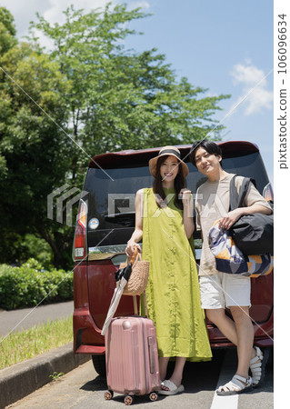 Smiling couple going on a trip by car during summer vacation 106096634