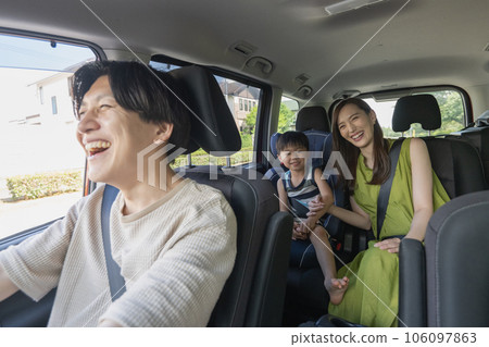 A smiling parent and child child-rearing family going on a family trip by car during summer vacation 106097863