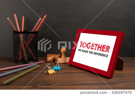 TOGETHER WE MAKE THE DIFFERENCE. A picture frame on the office table 106097970