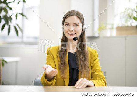 A smiling foreign business woman looking at the camera with an intercom A smiling foreign business woman looking at the camera with an intercom 106100440