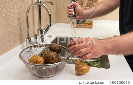 Sink and basket of dirty potatoes in the kitchen Sink and basket of dirty potatoes in the kitchen 106100680