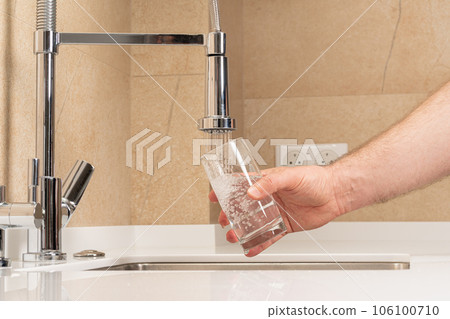 filling a glass with clean, clear drinking water 106100710