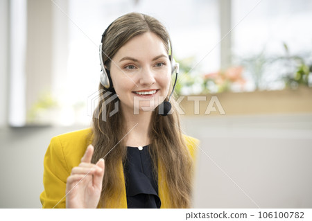 一位微笑的外國女士打開對講機並與她的電腦交談在線英語會話課程圖像 106100782