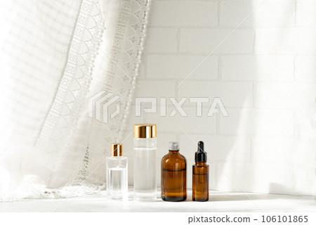 Four types of glass cosmetic bottles placed by the window 106101865