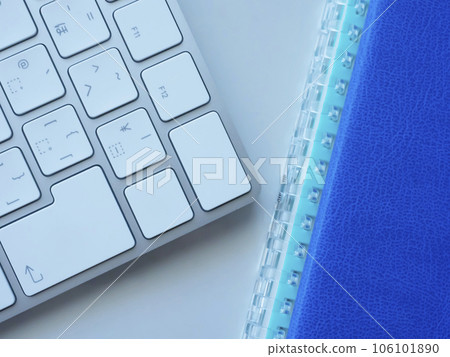 Blue notebook and keyboard on the table 106101890
