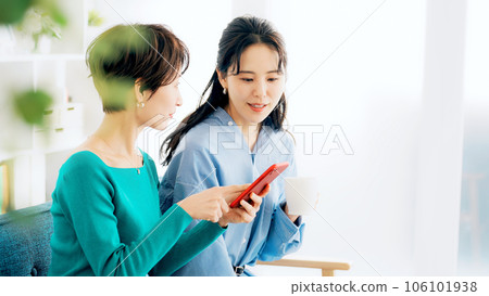 女人邊看智能手機邊聊天 女人邊看智能手機邊聊天 106101938