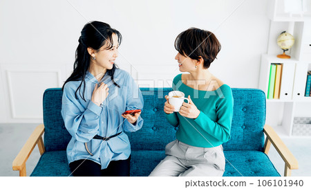 女人邊看智能手機邊聊天 106101940