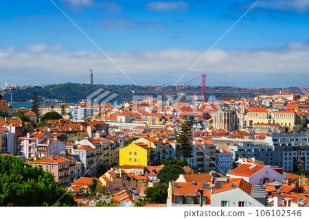 Lisbon famous view from Miradouro dos Barros tourist viewpoint over Alfama old city district, 25th of April Bridge and Christ the King statue. Lisbon, Portugal. 106102546