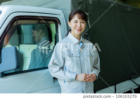 一名穿著工作服的女士站在卡車前 一名穿著工作服的女士站在卡車前 106103270