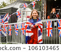 Cheerful beautiful young girl running with the flag of the UK on the celebration in England. Happy school kid. Education. Child is covered in British flag 106103465