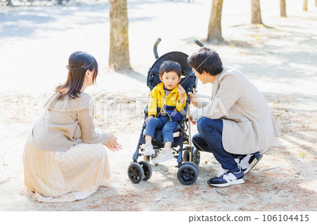 A family strolling along a tree-lined road in autumn 106104415