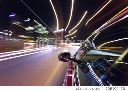 Blurred urban look from fast driving car to back side and driver at summer night. Longexposure shot. 106104430